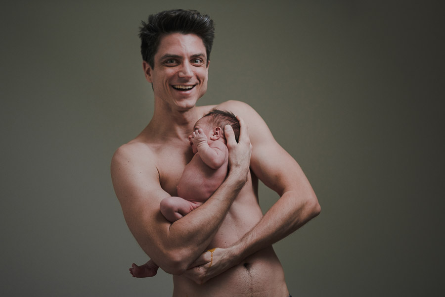 Papa hält Baby beide nackt Neugeborenes pinkelt und kackt vater lacht