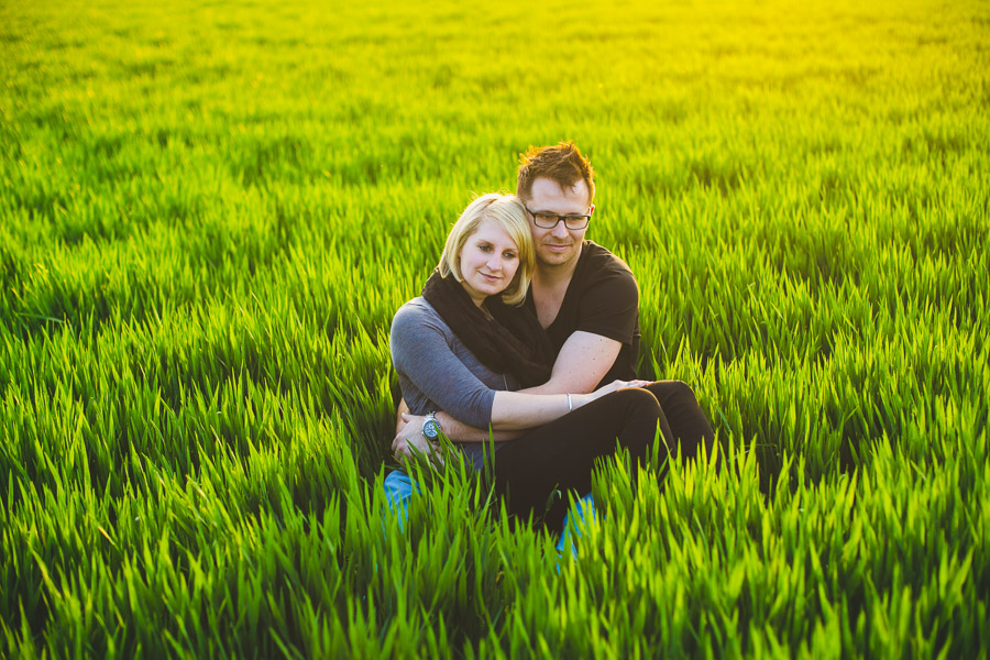 romantisches Paar umarmt sich im Feld bei Sonnenuntergang im Rahmen vom Engagement-Shooting