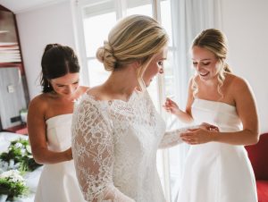 hochzeitsfotos-weisser-saal-schwestern-helfen-braut-mit-kleid