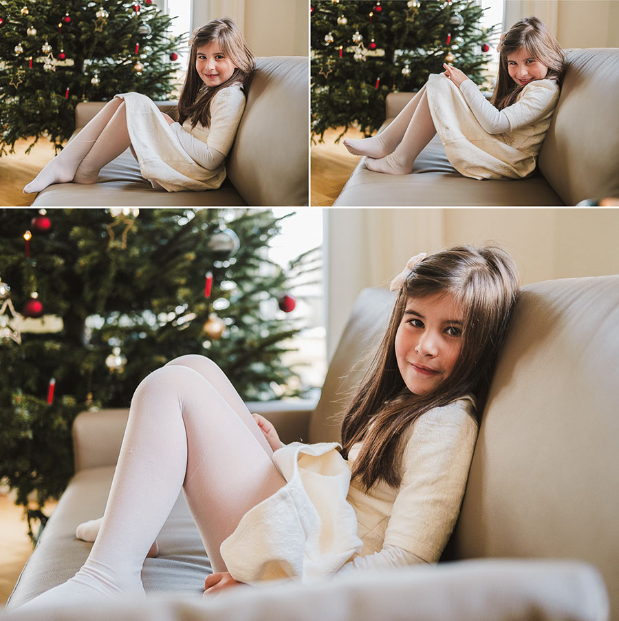 Mädchen sitzt auf dem Sofa vor dem Weihnachtsbaum – natürliche Weihnachtsfotos für Familien mit Kindern